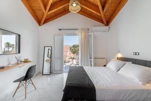 a bedroom with a bed and a table and a chair at Costa Azzurra Hotel in Skala Kefalonias