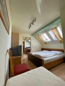 a bedroom with two beds and a tv and a window at Vural Rooms in Gmünd