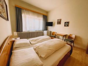 a hotel room with two beds and a window at Vural Rooms in Gmünd +2 photos