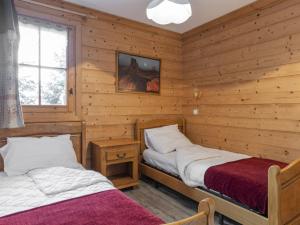 two beds in a room with wooden walls at Chalet Courchevel 1650, 6 pièces, 8 personnes - FR-1-514-69 in Courchevel