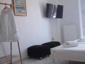 a room with two beds and a chair in it at Vrahos Studios in Kionia