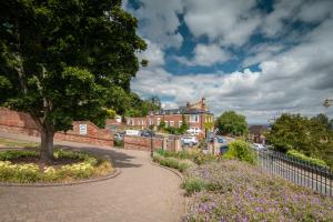 Una pasarela en una ciudad con un árbol y flores en Mount Pleasant Hotel, en Great Malvern