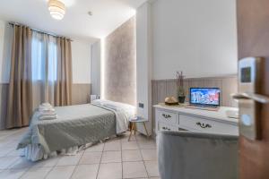 sypialnia z łóżkiem i laptopem na komodzie w obiekcie Villa Rocla guest house Pompei w mieście Pompeje