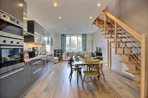 a kitchen and living room with a spiral staircase at KER LONGITUDE in Dinan