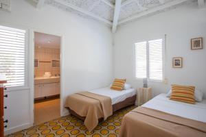 Cette chambre blanche comprend deux lits et une salle de bains. dans l'établissement Bungalow Seabass, à Willemstad