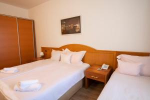 a hotel room with two beds with towels on them at Hotel Tourist - Metropol Lake Resort in Ohrid +28 photos