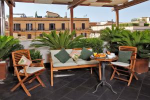 un patio con tavolo e sedie sul balcone. di Hotel Arcangelo a Roma