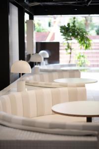 a room with white tables and white chairs at Pinpon Hotel Hiroshima in Hiroshima +63 photos