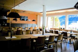 Un comedor con mesas y sillas y ventanas. en Geisler-Moroder, en Elbigenalp 37 fotos más