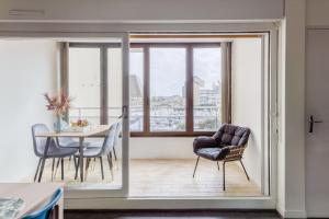 Habitación con mesa, sillas y ventana en La Boussole, en Courseulles-sur-Mer
