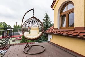 a swinging chair sitting on a balcony at Pokoje gościnne przy Rynku in Dąbrówno