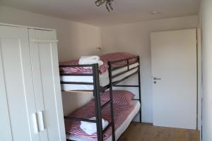 Zimmer mit 3 Etagenbetten mit roten und weißen Decken in der Unterkunft Giulia in Singen