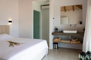 a bedroom with a white bed and a sink at Villa Aetos in Paleros
