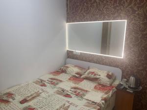 Dormitorio pequeño con cama y espejo en Lemberg Elite Apartments, en Leópolis