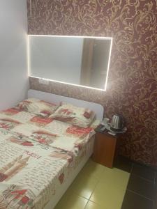 małą sypialnię z łóżkiem i lustrem w obiekcie Lemberg Elite Apartments w Lwowie