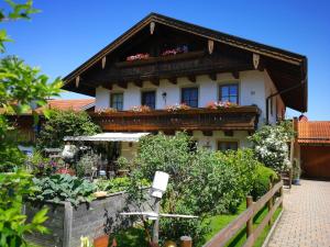 una casa con un balcón con flores. en Ferienwohnungen Kern, en Aschau im Chiemgau