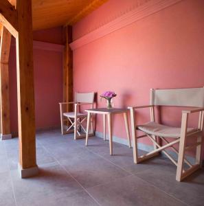 a table and chairs in a room with pink walls at Dluga Apartments in Krakow