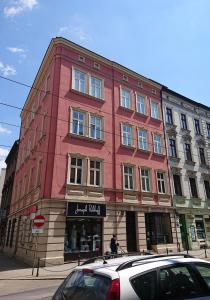 a red building on the corner of a street at Dluga Apartments in Kraków