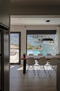 a dining room with a table and chairs and a pool at Villa Aetos in Paleros