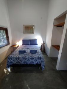 a bedroom with a bed with blue pillows at Casa Papa-Vento in Lençóis