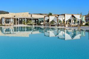 a pool of water with chairs and a building at Baglioni Resort Sardinia - The Leading Hotels of the World in San Teodoro +37 photos