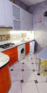 a kitchen with a sink and a washing machine at Apart Club Dzhambula in Chernivtsi +9 photos