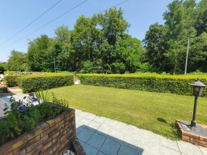 a garden with a brick fence and a lawn at La maison du Roi Vives Eaux in Boissise-le-Roi
