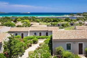 a row of houses with the ocean in the background at Baglioni Resort Sardinia - The Leading Hotels of the World in San Teodoro