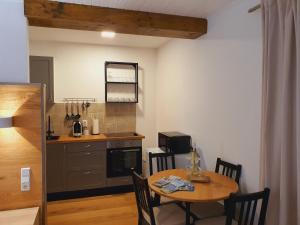 a kitchen with a wooden table and a table and chairs at Winter Cozy Escape - Near Ski Gerlitzen in Bodensdorf
