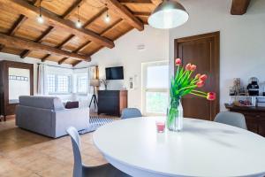 a living room with a white table and flowers at Casale Le Brecce in Otricoli
