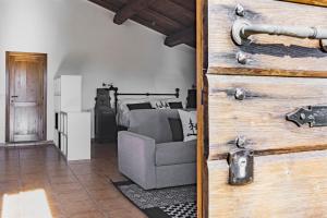 a living room with a couch and a wooden door at Casale Le Brecce b&b in Otricoli