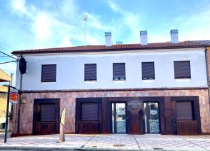 un edificio blanco con puertas marrones en una calle en Apartamentos Puertas del Orbigo, en Carrizo de la Ribera