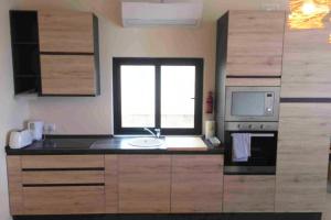 a kitchen with a sink and a microwave at Mellieha Luxury Penthouse with sea & country views in Mellieħa