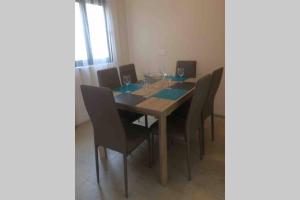 a dining room table and chairs with wine glasses on it at Mellieha Luxury Penthouse with sea & country views in Mellieħa