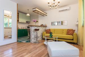 sala de estar con sofá amarillo y mesa en Best Apartment Roxy, en Dubrovnik