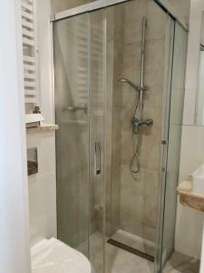 a glass shower with a toilet in a bathroom at Hotel Piast in Słupsk
