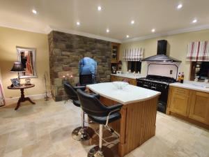 a kitchen with an island and a stone wall at 'Clíona' Deluxe Double Room in Foxford