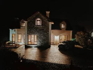a house with a car parked in front of it at night at 'Clíona' Deluxe Double Room in Foxford