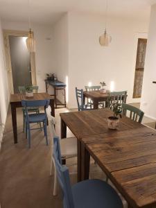 un comedor con mesas de madera y sillas azules en Casa Lunaria B&B en Porto SantʼElpidio