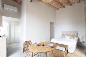 1 dormitorio con cama, mesa de madera y sidra de mesa en Caelus Boutique Studio, en Girona
