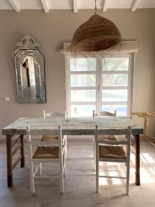 a dining room table with two chairs and a mirror at Casa Paloma in Comporta