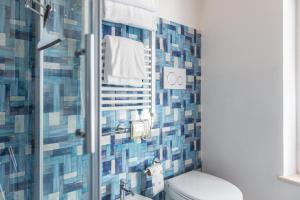 a bathroom with a toilet and a shower with blue tiles at Fruttadamare in Porto Recanati