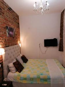 a bedroom with a bed and a brick wall at Excellency apartmani in Banja Luka