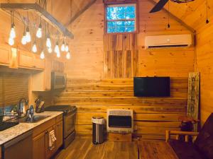 a kitchen with wooden walls and a tv on the wall at windrock ridge - Liahn in Oak Ridge