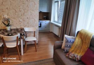 ein Wohnzimmer mit einem Tisch und einem Sofa in der Unterkunft Jakobi Guest Apartment in Tallinn