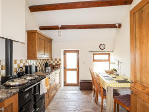 a kitchen with a table and a stove top oven at Penrallt Fawr in Caernarfon