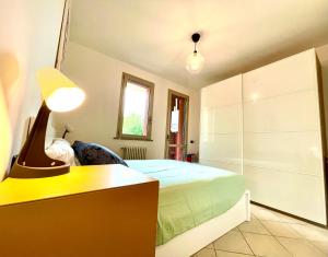 a bedroom with a bed and a desk with a lamp at Burò il Viaggiatore in Parma