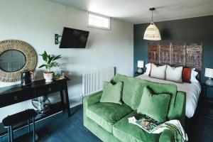 a living room with a green couch and a bed at The fig in Rye