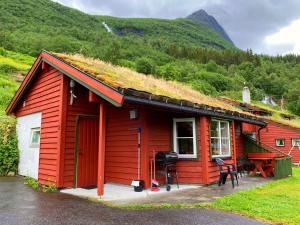 Cabaña roja con techo de hierba en Hole Hytter, en Geiranger