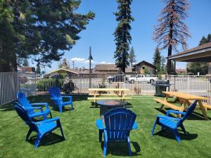 een groep blauwe stoelen en tafels in een tuin bij Bluebird Day Inn & Suites in South Lake Tahoe